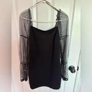 Black mini dress with long mesh sleeves and attached pearls